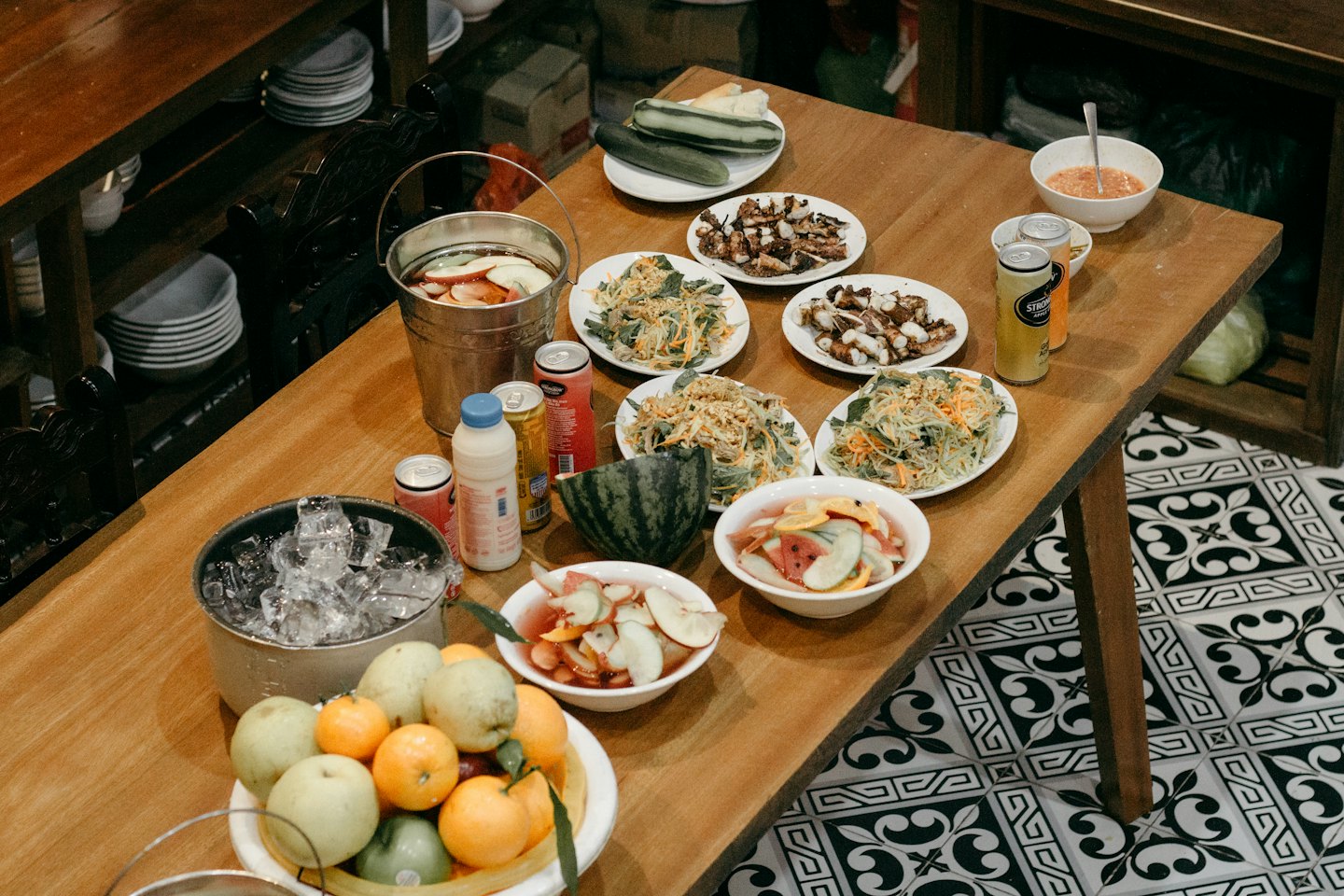Table rustique garnie de salades, de poulpe grillé et de fruits frais.