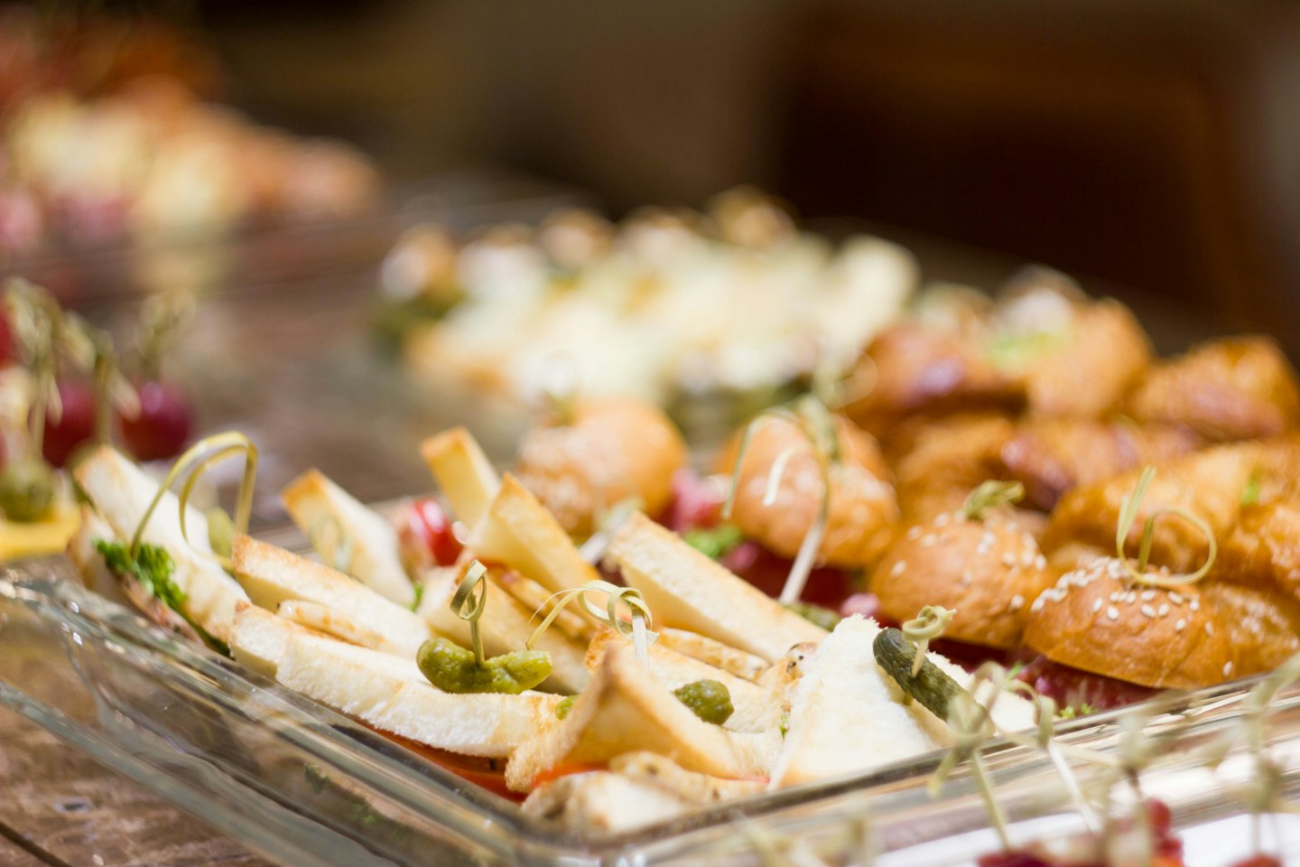 Mini sandwichs et sliders sur plateaux en verre.